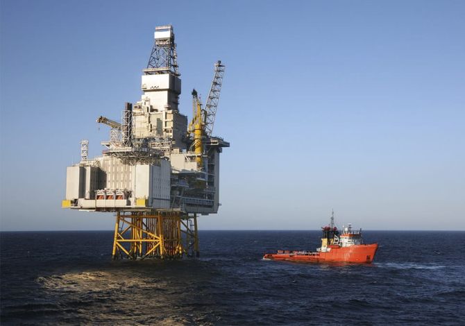 After a safe crew transfer using a Reflex Marine device, a ship sails away from an oil rig.