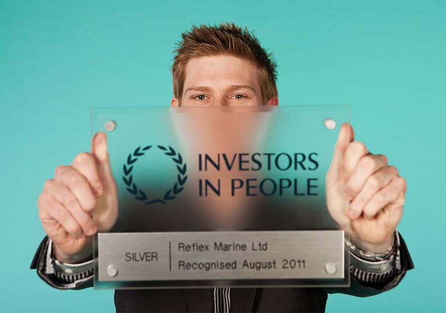 James Strong holding the Silver Award for Investors in People, which Reflex Marine won in 2011 and 2014.