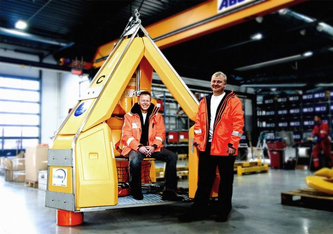 Two men in warehouse posing with a Reflex Marine FROG transfer device.